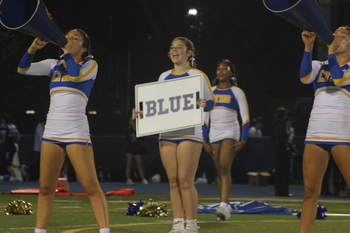 Competitive cheerleader Erin Gugliuzza 26’ holds up cheer sign. (Albores/LION).