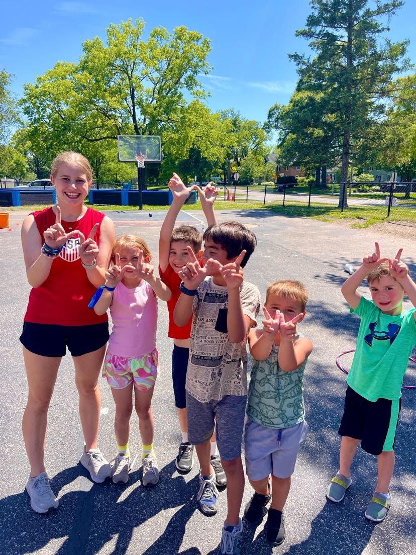 Nora Hare ‘25 holds up “W” with campers (courtesy of Fielding). 