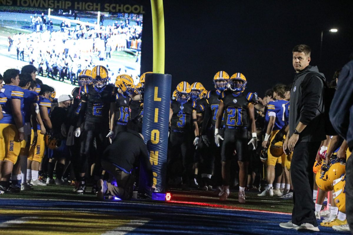 Team captains lead the team out of the tunnel before Salute to Service game against OPRF on Oct. 4