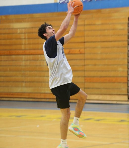 Forward Gavin Carolan ‘25 skies up for a rebound while doing drills during Dec. 3 practice (Schmidt/LION). 
