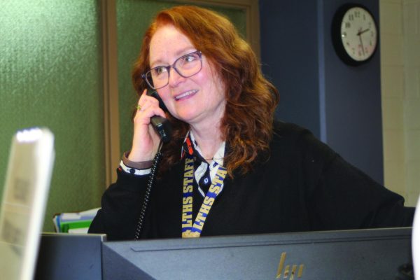 Paraeducator Kathleen Brand-White takes a call in the health office at NC on Nov. 19