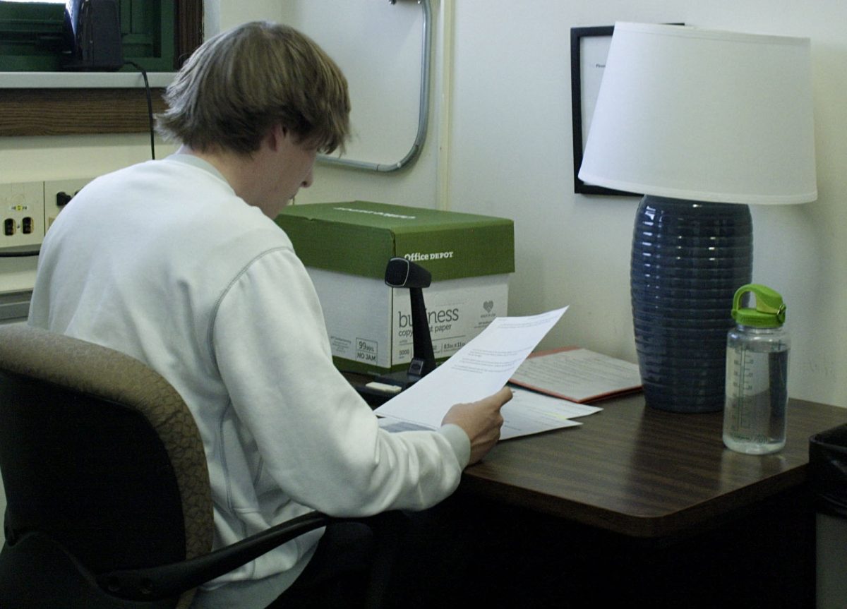 Jack Grier ‘25 reads the announcements over the new PA system in the NC main office on Jan. 29.  The new PA system was installed over winter break (Brooke Stack/LION).
