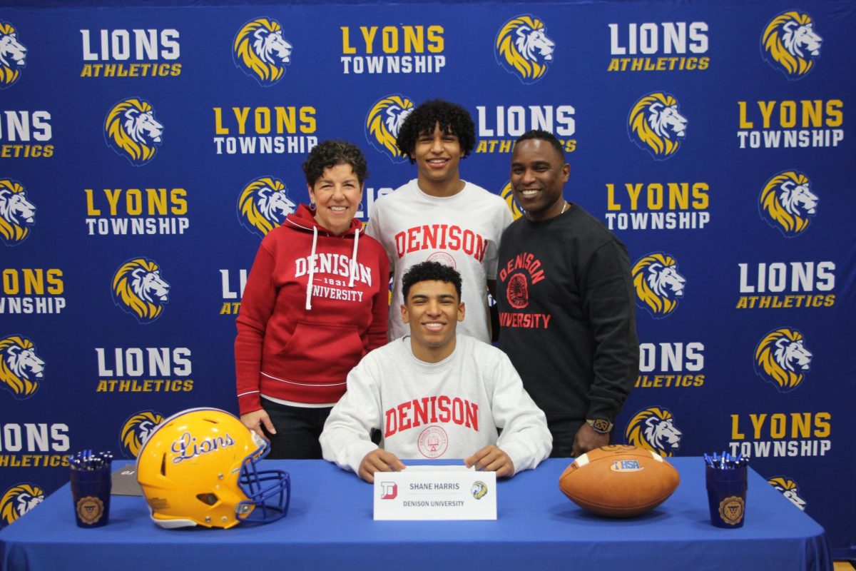 Shane Harris ‘25 smiles with his family after his signing to Denison University football (Forebaugh/LION).