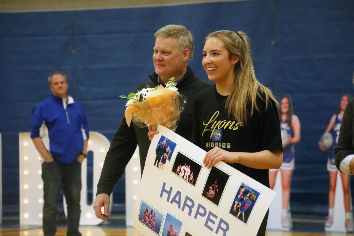 Harper Carroll ‘25 approaches the team after receiving posters and flowers from teammates and father (Brooks/LION).
