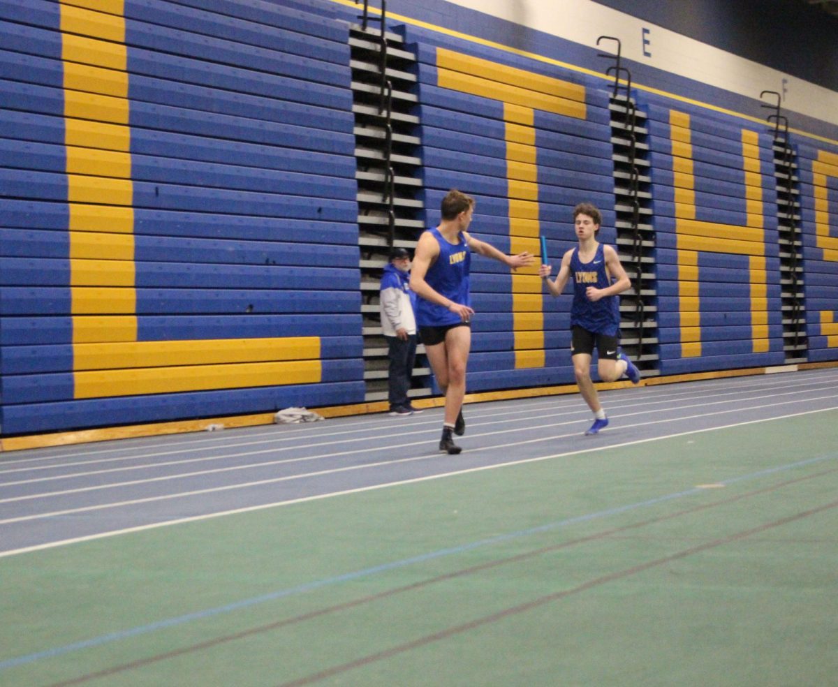 Will Cormier ‘26 passes the baton to Porter Gourley ‘26 in the 4x400 relay during LT’s meet against Plainfield Central and Benet on Feb. 20 in the SC Fieldhouse (Forebaugh/LION). 
